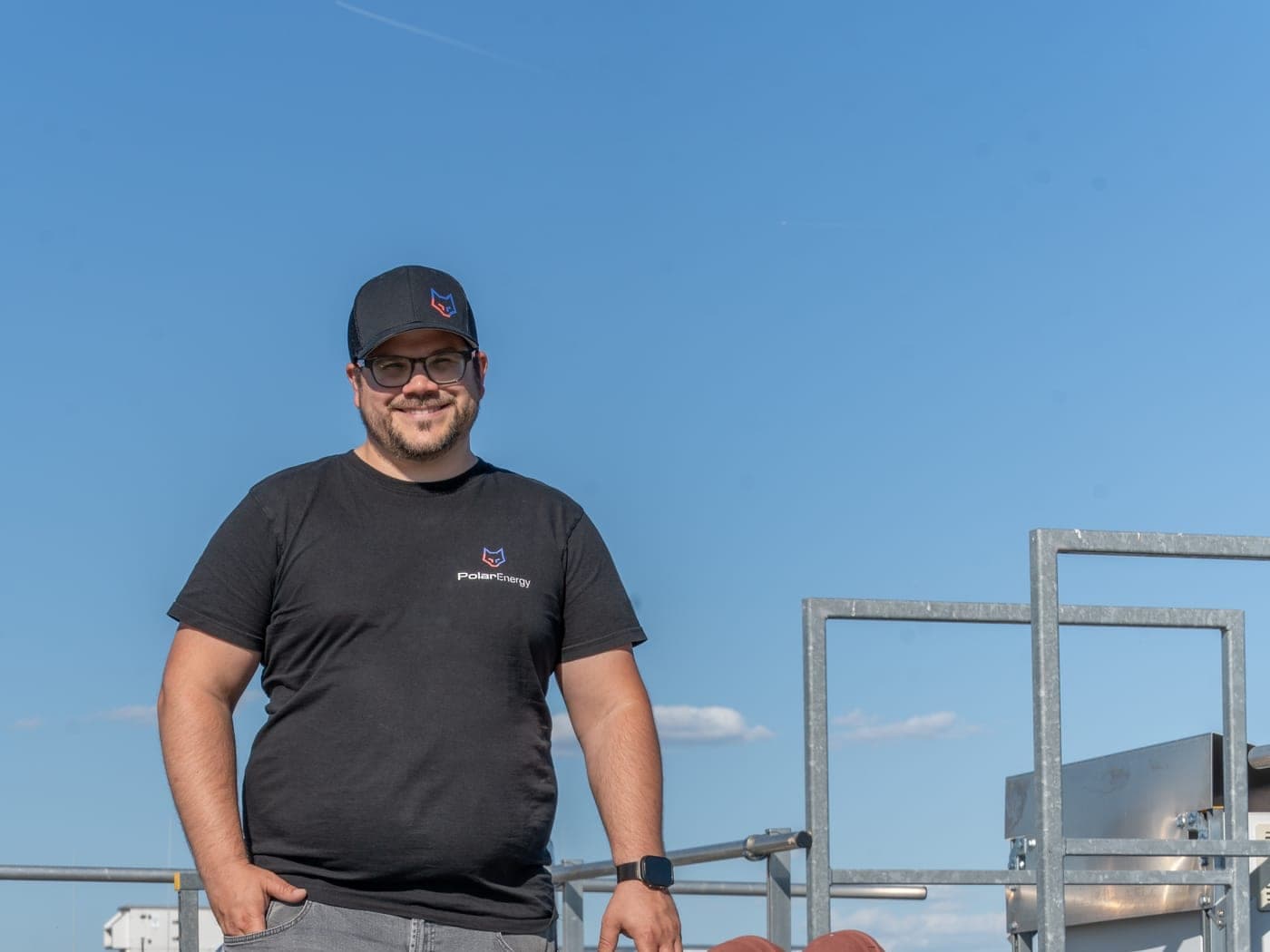 Polar-Energy-Techniker neben einem Klimaaußengerät auf dem Dach